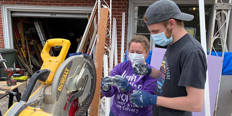 Two students working with a power saw during a Spring Service Partnership