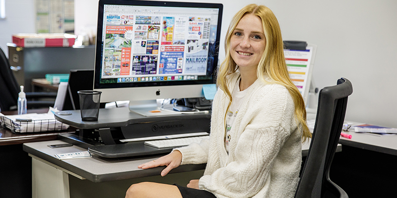 NWC alum seated at her desk