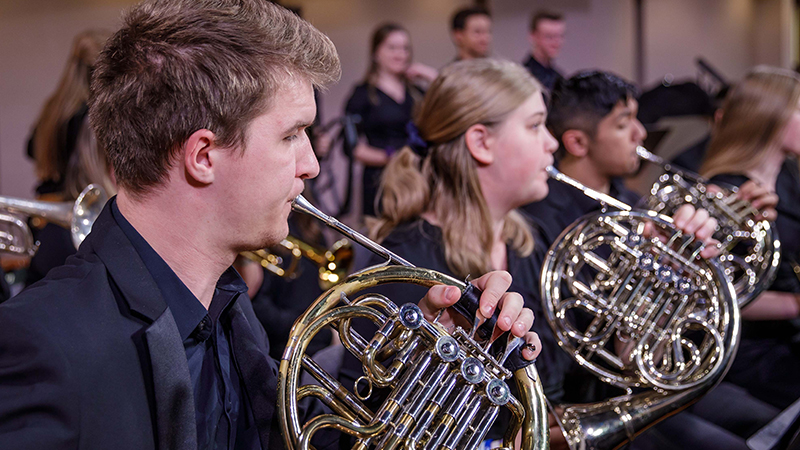 Student musicians playing French horns