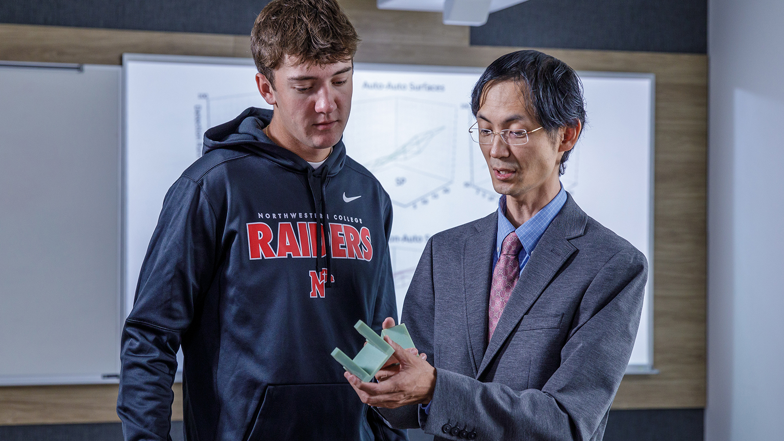 Dr. Young-Ji Byon, founding director of the engineering program, working with a student