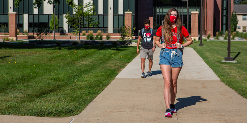 Two students walking across campus