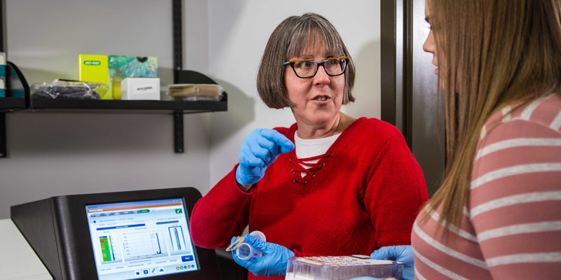 Dr. Sara Tolsma and student working with DNA sequencer