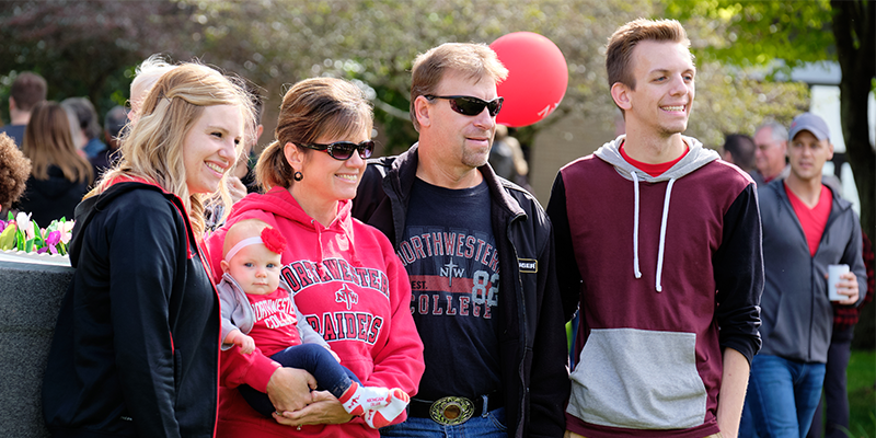 Northwestern student poses for a photo with family at 2019 Raider Nation Celebration