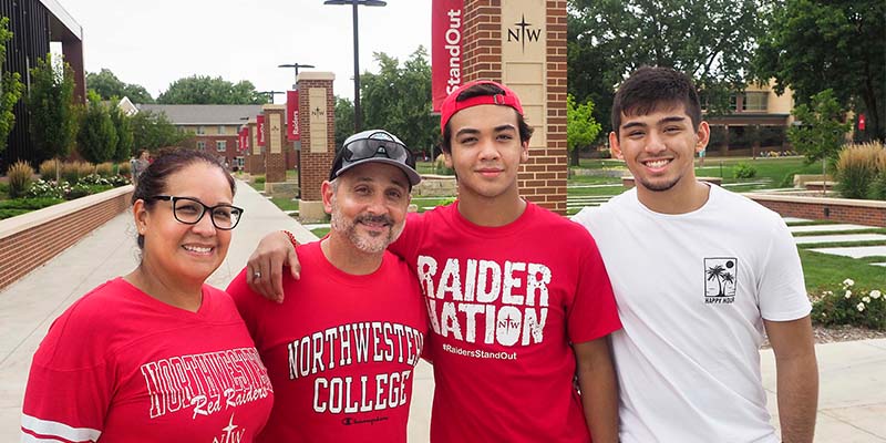 Latino student poses for photo with his family at 2021 Orientation