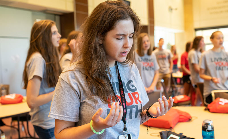 Student in worship at Living Your Faith camp 