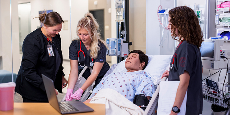 Nursing students treat a patient during a practice simulation