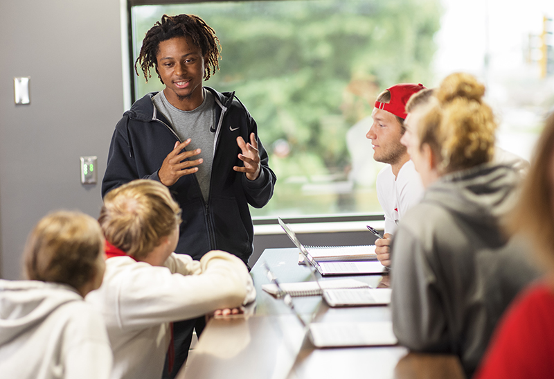 Northwestern College business students talk in a small group.