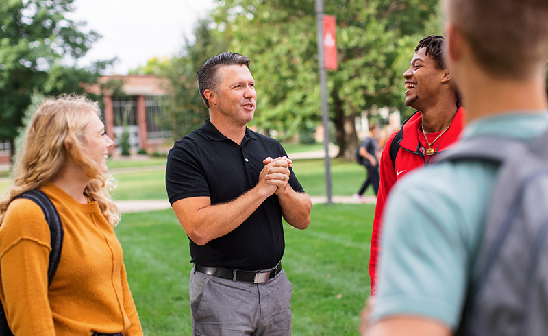 Students and faculty talking with one another on the campus green