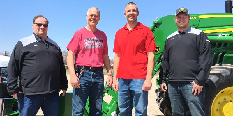 Maintenance employees with donated tractor