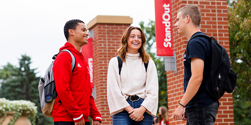 Students talk together in a campus plaza