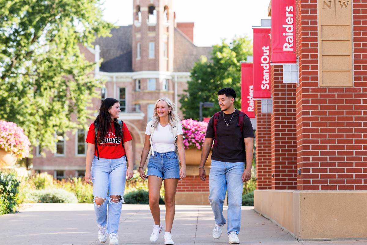 Two female students and one male student walking to class