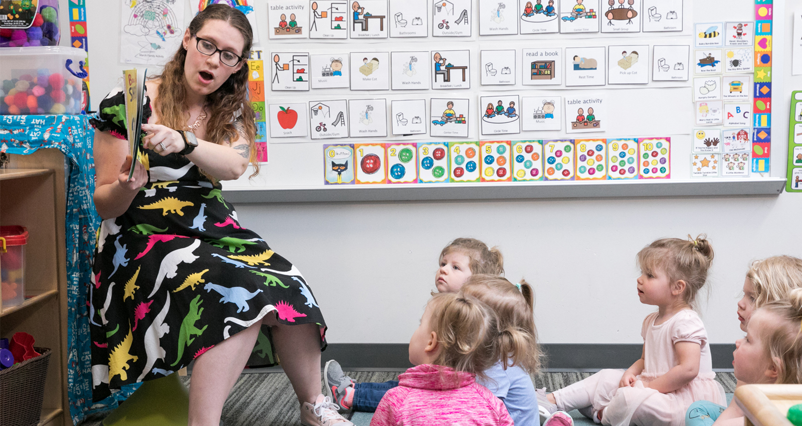 An early childhood educator reading a book to her class